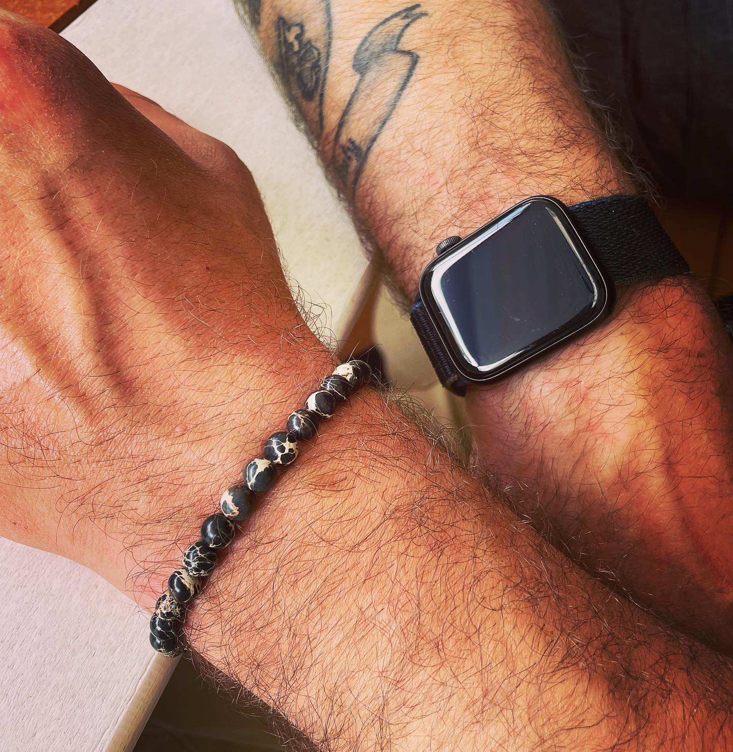 A man wearing the black impression jasper beaded bracelet from Featherly
