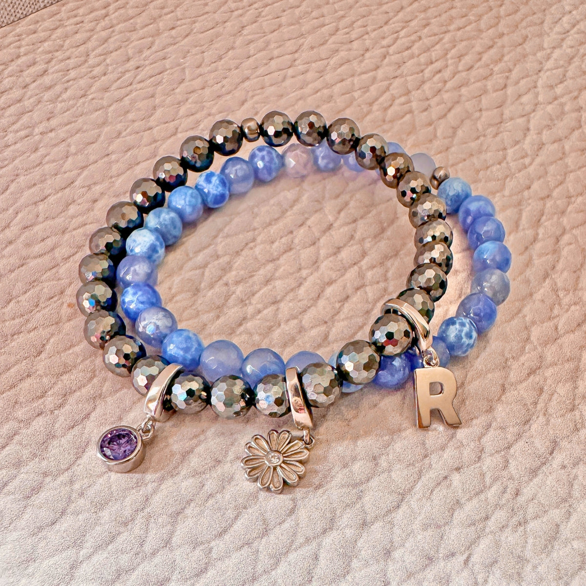 charms for a bracelet with birthstone charm, flower charm, and initial charm