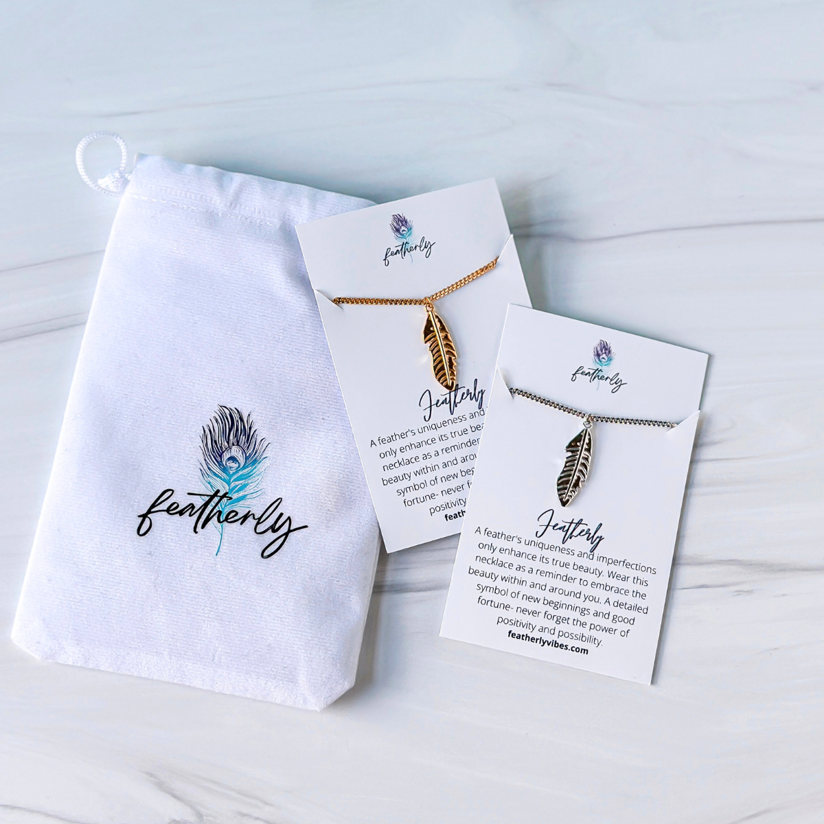 silver and gold feather necklaces on adjustable chain with Featherly white velvet pouch