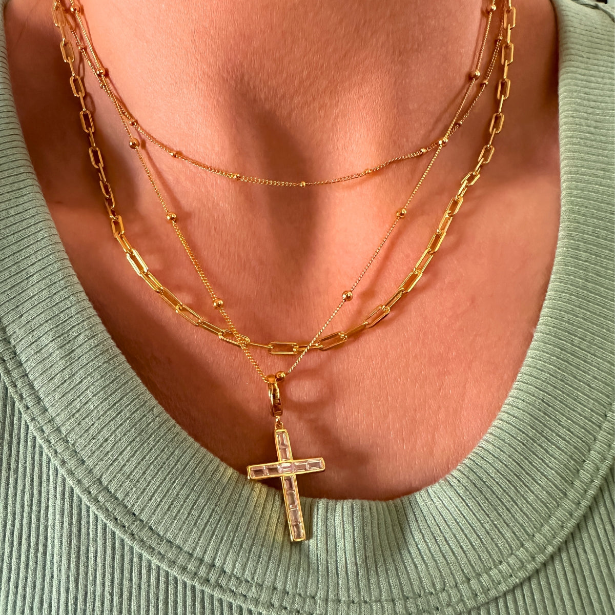gold cross charm turned into a cross pendant necklace on gold satellite chain from Featherly jewelry