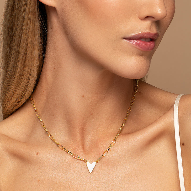 Model wearing the Featherly white enamel heart paperclip chain necklace in gold