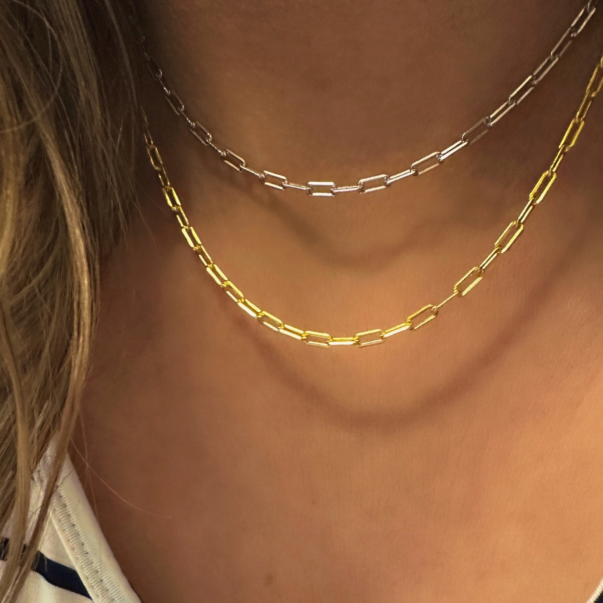 Featherly gold and sterling silver paperclip chain adjustable necklaces layered together on a model